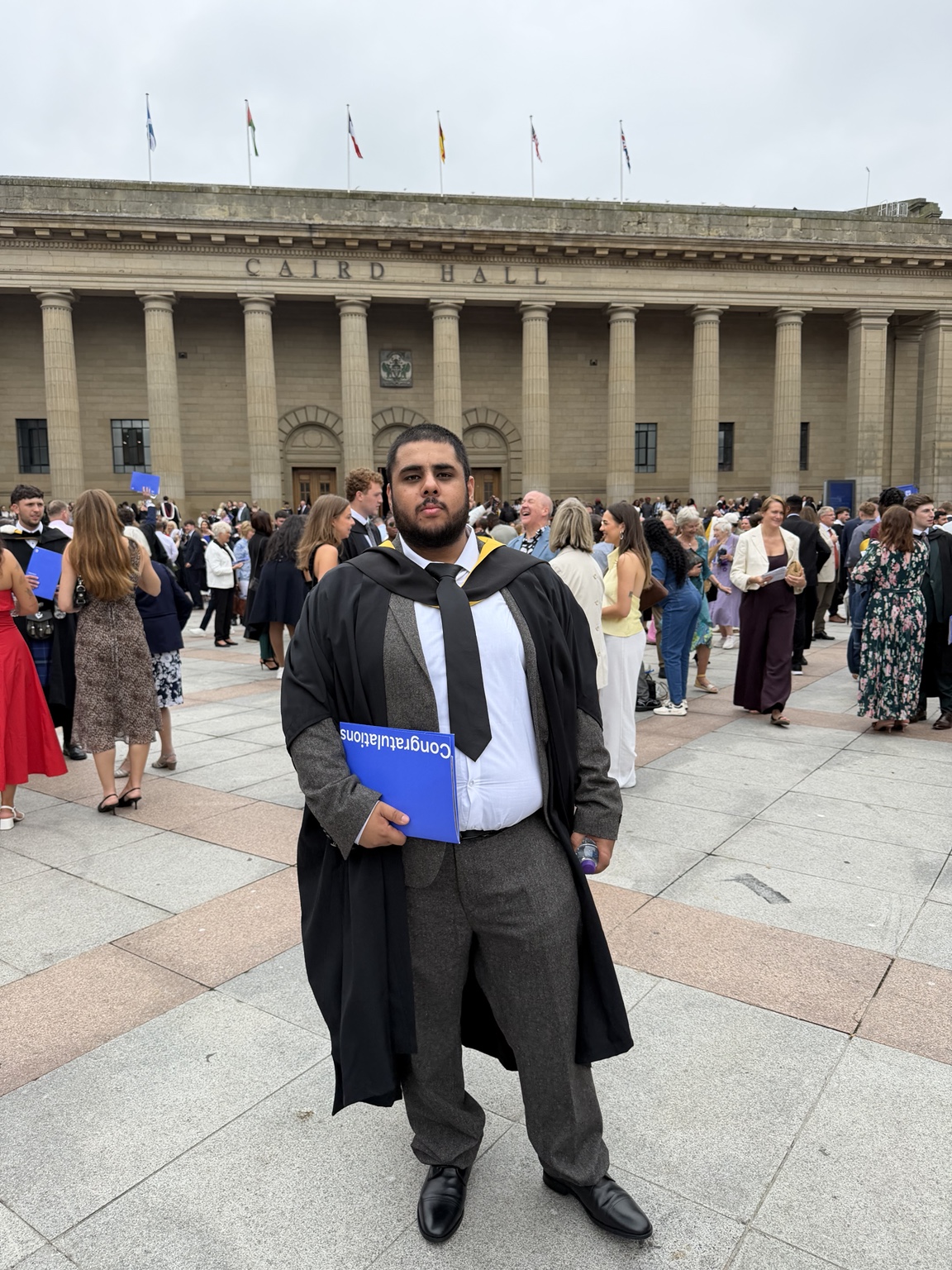 Ibne Shukran holding his graduation folder