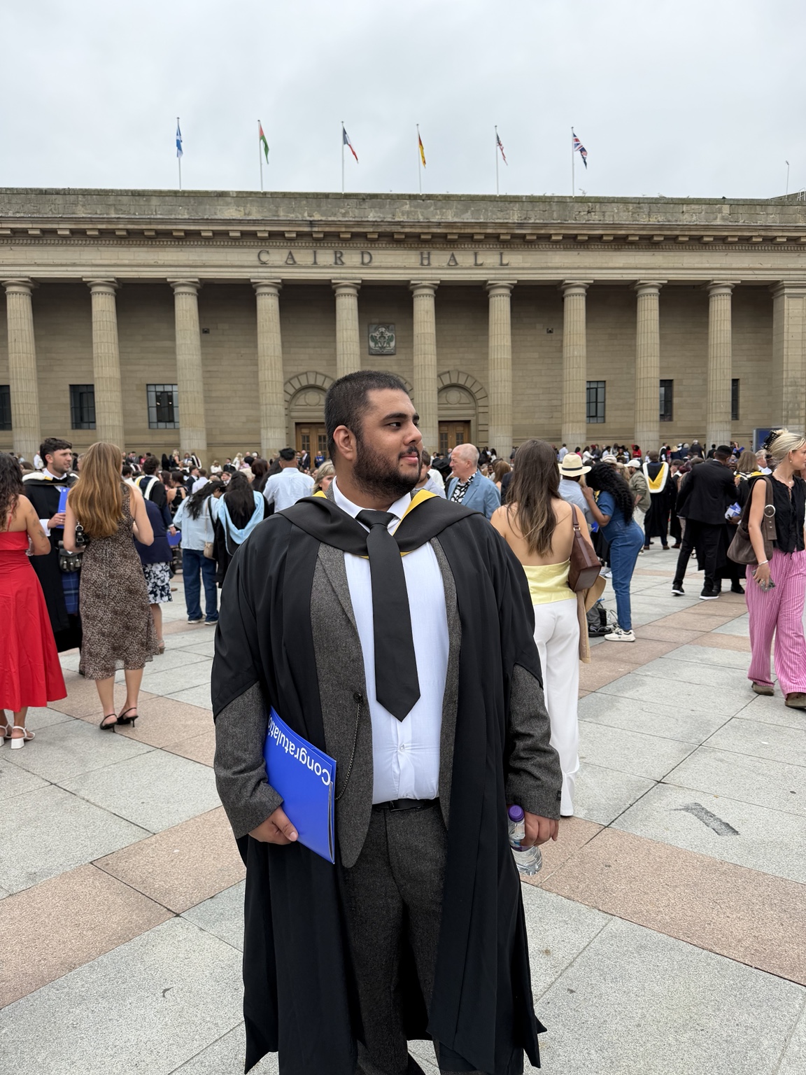 Ibne Shukran in graduation robes outside Caird Hall